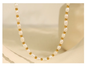 Detailed view of French vintage baroque pearls and golden metal beads on a beige cloth