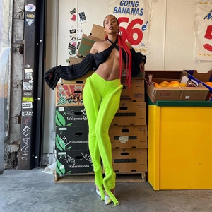 Detail der neongrünen gerippten Hose mit schwarzem Wickel-Oberteil für einen Street-Style