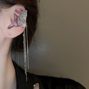 Macro detail of silver butterfly ear cuff with sparkling zircon and long tassels on model