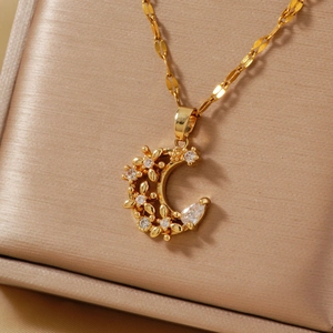 Elegant gold crescent moon necklace with micro-set zircon flowers on jewelry box