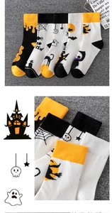 Detail of Halloween socks with knitted pumpkins, ghosts and bats patterns in orange and black