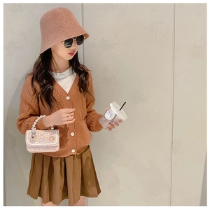 Detail of pink pearl chain handbag with wool hat and brown knit girl's outfit