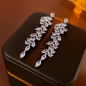 Macro view of long silver teardrop earrings with marquise-cut zircon leaf patterns