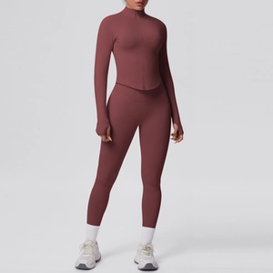 Dettaglio della giacca da yoga con asole per i pollici e leggings a vita alta rossi