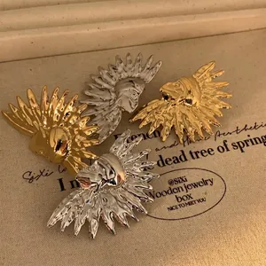 Unique stainless steel lion head stud earrings in gold and silver finish on canvas