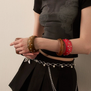 Retro wide wood bangles with metal studs and pearl chain belt on a female model