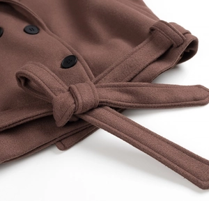 Détail d'un manteau en laine marron avec boutons à double boutonnage et ceinture nouée