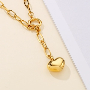 Close-up of golden square link chain necklace with polished heart pendant and OT clasp