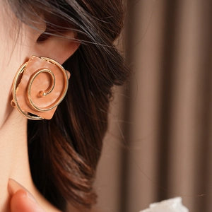 Detail of vintage square spray-paint clip-on earring with golden spiral on a female model