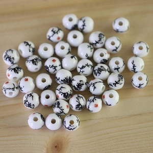 Macro detail of round ceramic beads with Chinese ink bamboo patterns on wood background