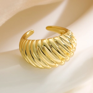 Minimalist gold-plated croissant dome ring with a textured finish on white silk