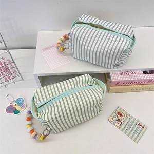 Close-up of seersucker striped tissue pouches with colorful beaded handle and zipper