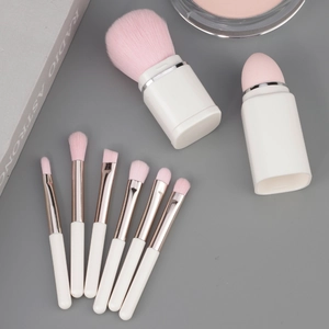 8-in-1 pearlescent makeup brush set with pink fibers and white handles on gray background