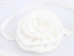 Detail eines weißen 3D-Stoffblumen-Haaraccessoires mit feiner Seidentextur auf elastischem Band