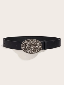 Macro shot of vintage floral engraved silver oval buckle on a black faux leather belt