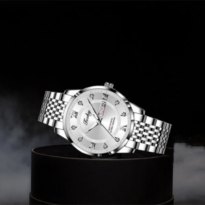 Detailed close-up of a silver business watch with dual-calendar display and steel band