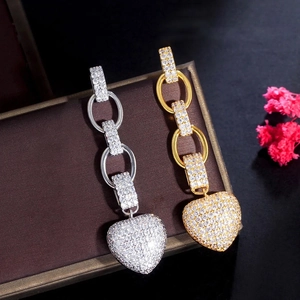 Macro detail of heart drop earrings featuring micro-pave crystals on jewelry box