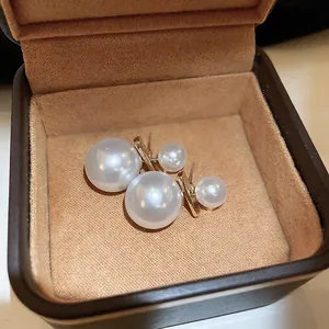 Elegant double pearl earrings with gold bar connectors in a velvet jewelry box