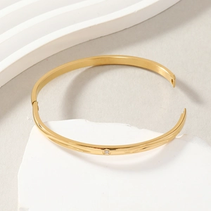 Minimalist gold plated stainless steel O-clasp bangle with a sparkling cubic zirconia stone