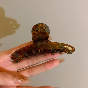 Détail d'une pince à cheveux écaille avec inscription dorée France Handmade