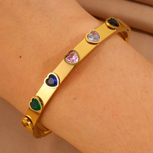 Détail des zircons multicolores en forme de cœur incrustés sur le bracelet doré
