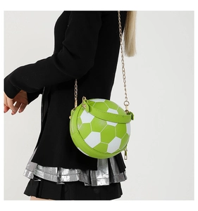 Model showing green and white football shaped crossbody bag with gold chain strap