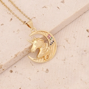 Macro shot of 18K gold unicorn and crescent moon pendant with colorful zircon stones