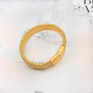 Close-up of golden Tubogas spiral bracelet with elastic structure and metal buckle