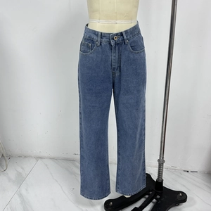 Detail of high waisted straight leg blue denim jeans showing the waist and button closure