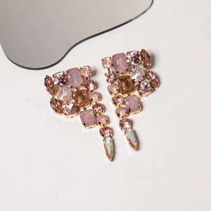 Detail of pink crystal teardrop earrings with golden alloy base for gala parties