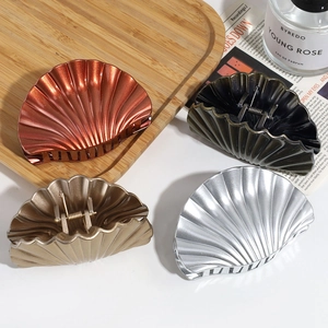 Set of four vintage shell-shaped hair claws in bronze, silver, and black metal finishes