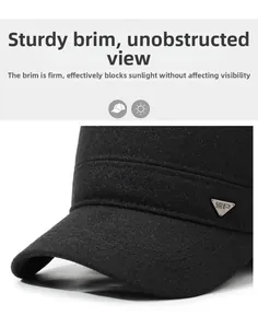 Detailed close-up of a black wool flat cap featuring a metallic triangular emblem