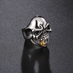 Close-up of vintage silver skull ring with a detailed gold rose in its mouth