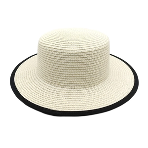 Top view of beige straw sun hat featuring a distinct black contrast edge trim