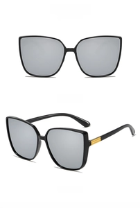 Detail view of square black sunglasses with silver mirrored lenses and golden temple accents