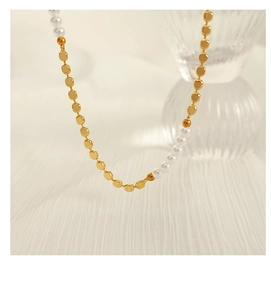 Detail of minimalist gold square link chain and white freshwater pearls necklace