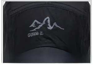 Detail of mountain embroidery and outdoor lettering on breathable quick-dry cap fabric