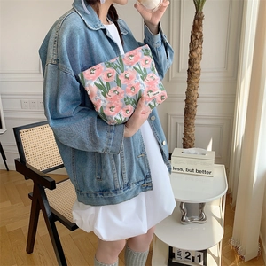 Floral cotton makeup bag with pink flowers held by a model in a minimalist room