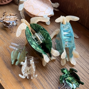 Detailed view of various tortoise-shaped acetate hair claws in multiple marble colors