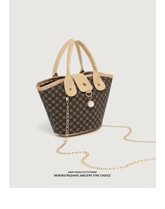 Detail of brown patterned bucket bag with khaki leather handle, chain strap and pearl charm