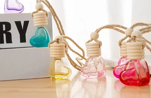 Detail of colorful heart-shaped glass aromatherapy bottles with wooden caps and hanging cords