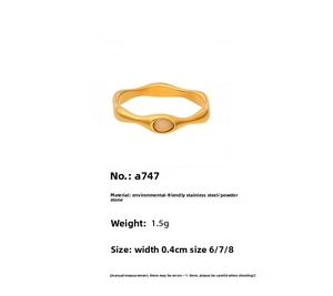 Detail view of rose quartz stone ring with gold wave band and stainless steel specs
