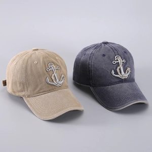 Detail of washed cotton baseball caps with anchor embroidery in khaki and navy blue