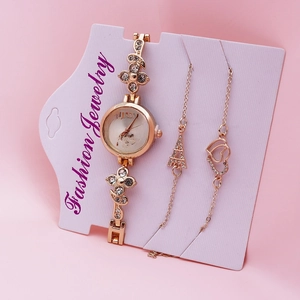 Detail of gold quartz watch and two bracelets with Eiffel Tower and heart charms