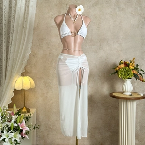 Detail of white mesh beach skirt with drawstring and bikini top on a mannequin