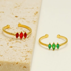 Detailansicht goldener Ring mit Hammerschlag-Textur und roten sowie grünen Zirkonia-Steinen