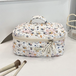 Detailed shot of quilted cotton makeup bag featuring cute puppy print and decorative ribbon