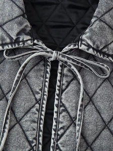 Detail of diamond quilted denim jacket with stone washed finish and bow tie collar
