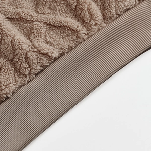 Detail of coffee brown faux shearling fleece fabric and elastic ribbed hem stitching
