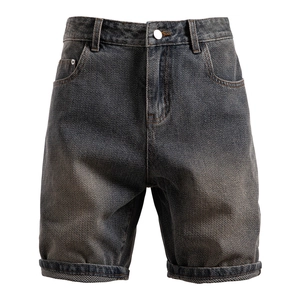 Detailed macro view showing the unique herringbone weave texture of dark grey denim shorts